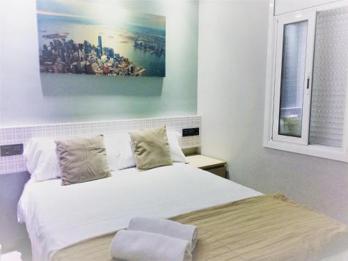 a bedroom with a white bed and a painting on the wall at Barcelona Fifteen central Aparthotel in Barcelona