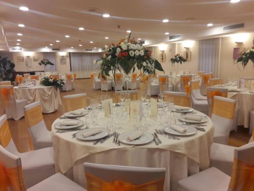 a banquet hall with white tables and white chairs at Hotel In Sylvis in Sesto al Reghena