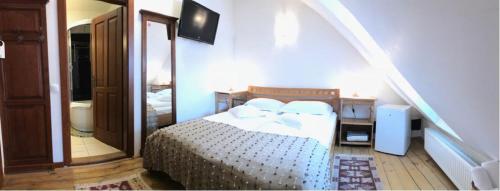 a bedroom with a bed in a room with a staircase at Pensiunea Gasthaus Alte Post in Sighişoara
