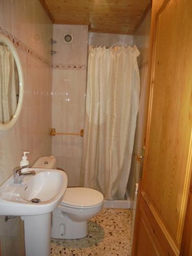 a bathroom with a white toilet and a sink at Ca la Viola in Marçà