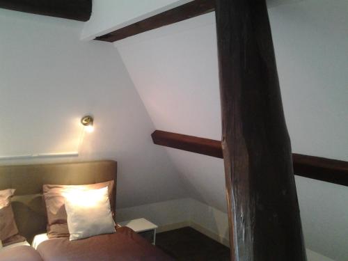 a room with a bed and a wooden beam at Bed & Breakfast Meinsma in Moddergat