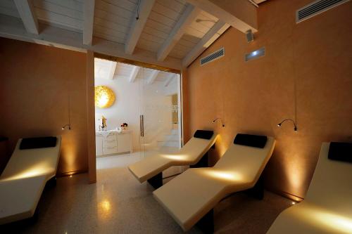 a room with two white benches and a bathroom at Hotel Ai Reali - Small Luxury Hotels of the World in Venice