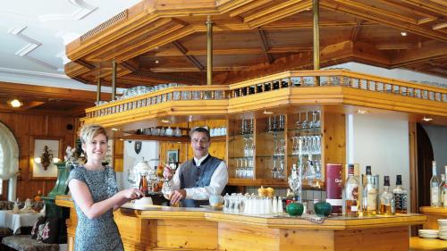 a man and a woman standing at a bar at Hotel Schwarzenbergs Traube in Glottertal