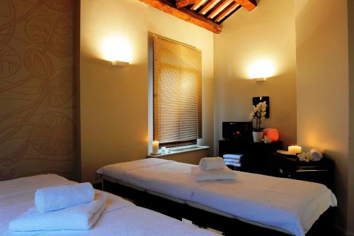 two beds in a room with a window and a desk at Hotel Ai Reali - Small Luxury Hotels of the World in Venice