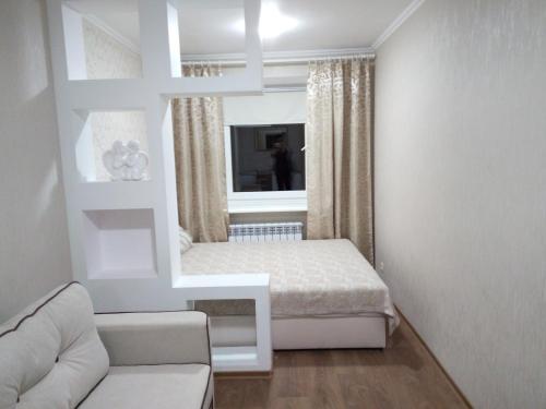 ein weißes Zimmer mit einem Bett und einem Spiegel in der Unterkunft Two-bedroom apartment in the center in Chmelnyzkyj