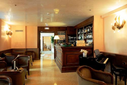 a bar in a restaurant with chairs and a counter at Hotel Ai Reali - Small Luxury Hotels of the World in Venice
