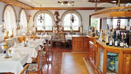 a restaurant with white tables and chairs and windows at Hotel Schwarzenbergs Traube in Glottertal
