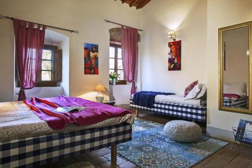 a bedroom with two beds and a mirror at Il Molinaccio in Gaiole in Chianti