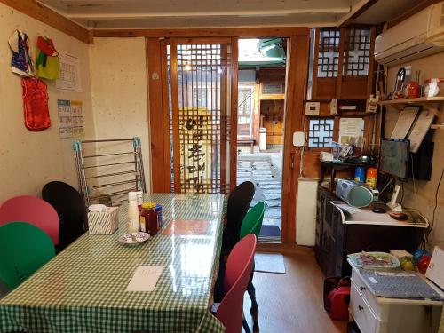 uma sala de jantar com uma mesa e cadeiras e uma porta em Gongsimga Hanok Guesthouse em Seul