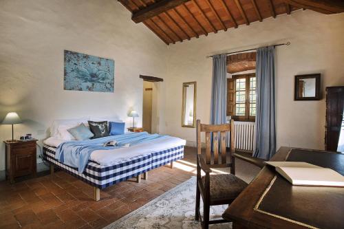 a bedroom with a bed and a table in a room at Il Molinaccio in Gaiole in Chianti