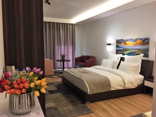 a hotel room with a bed and a vase of flowers at Mateus Hotel in Jounieh