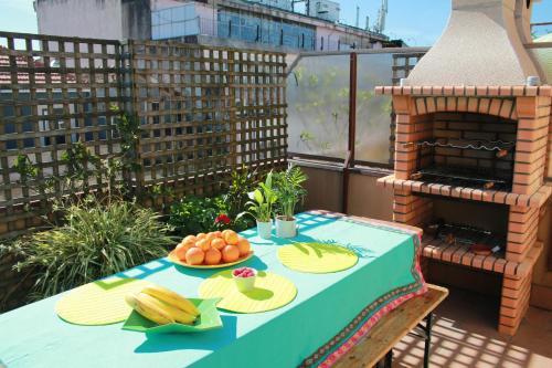 a table with a blue table cloth and fruit on a balcony at Cozy Apartment with Terrace, Air Cond, Free Parking in Porto