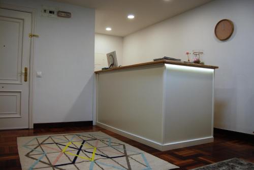 a room with a white wall and a counter at Hostal San Fernando in Santander