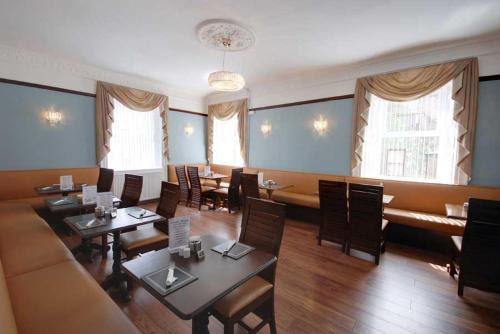 a restaurant with tables and chairs and a couch at Waverley Hotel in Peterhead