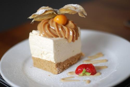 un trozo de pastel en un plato blanco con una fresa en Waverley Hotel en Peterhead
