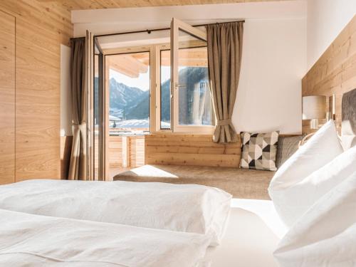 a bedroom with a bed and a large window at SonnenNEST mit SAUNA in Mayrhofen