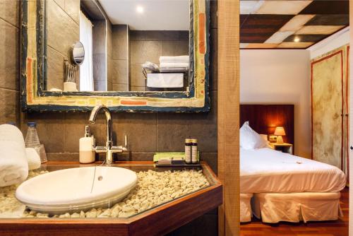 a bathroom with a sink and a bed at Hotel La Casueña in Lanuza