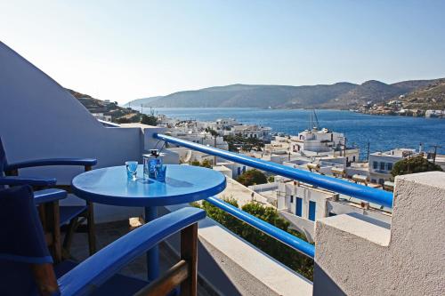 a blue table on a balcony with a view of the water at Pension The Big Blue in Katapola