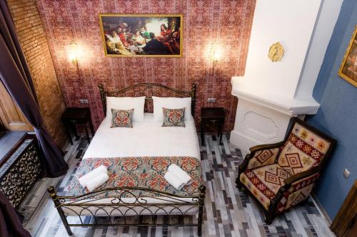 a bedroom with a bed and a painting on the wall at Tiflis Inn Boutique Hotel in Tbilisi City
