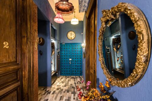 a hallway with a mirror and a blue wall at Tiflis Inn Boutique Hotel in Tbilisi City