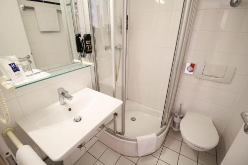 a bathroom with a sink and a shower and a toilet at Hotel Miramar am Römer in Frankfurt