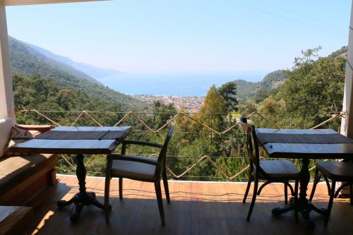 a balcony with two tables and chairs and a view at Ölüdeniz Loft - Adults Only in Oludeniz