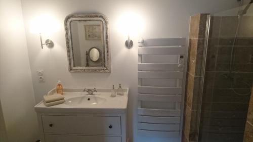a bathroom with a sink and a shower with a mirror at Mazet Des Artistes in Mouriès