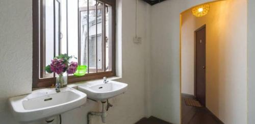a bathroom with two sinks and a window at Cocoa Mews Cafe and Homestay in George Town