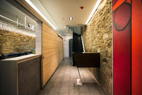 a corridor of a bathroom with a stone wall at Hotel Lois in A Coruña