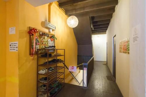a hallway with yellow walls and a shelf with shoes at Cocoa Mews Cafe and Homestay in George Town