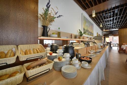 a buffet line with baskets of bread and dishes at Hotel Grand Litava Beroun in Beroun