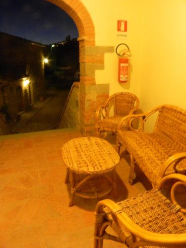 a patio with wicker chairs and a table and a fireplace at Casale l'Antico Carro in Cortona