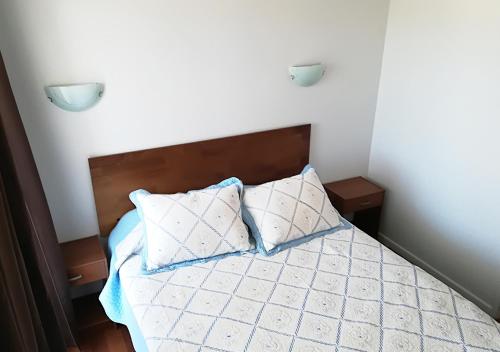 a bedroom with a bed with two pillows on it at Piedra Mar in El Quisco