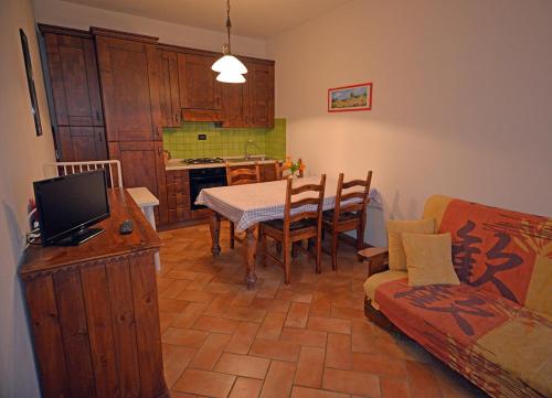 a living room with a table and a kitchen with a couch at Agriturismo Le Capanne in San Dalmazio
