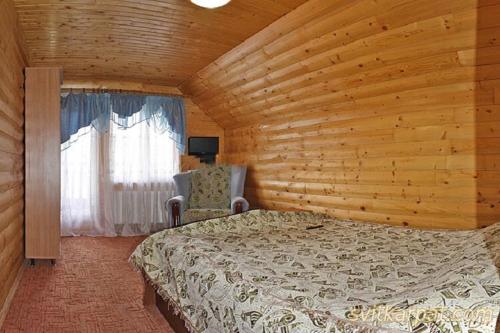 a bedroom with a bed and a chair in a room at Сонячні Карпати in Slavske
