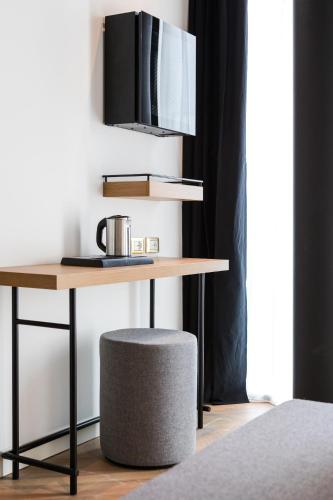 a wooden table with a stool next to a desk at MaisonMe Boutique Hotel in Bardolino