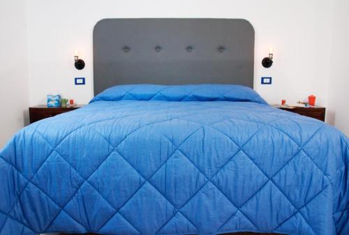 a blue bed with a blue quilt on it at Le stanze di Bruno in Pescara