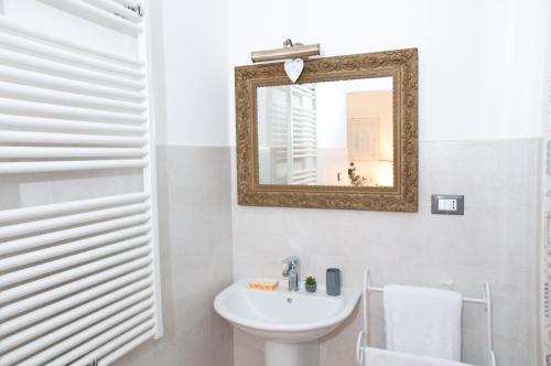 a white bathroom with a mirror and a sink at Le stanze di Bruno in Pescara