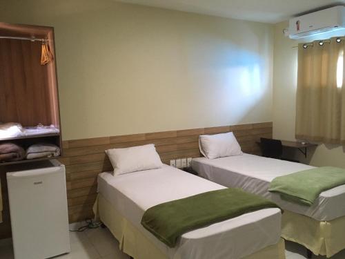 a room with two beds and a window at Pousada Sumaré in Caruaru