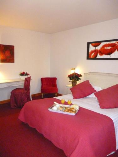 a hotel room with a bed with a tray of food on it at Hôtel Picardia in Saint-Valery-sur-Somme