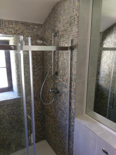 a shower with a glass door in a bathroom at The Old Piggeries in Gulval