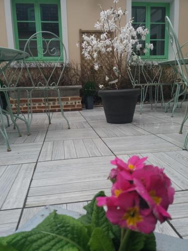 a group of chairs and flowers on a patio at Hôtel Picardia in Saint-Valery-sur-Somme
