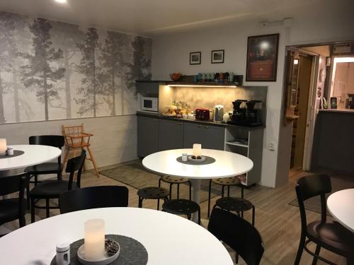 a restaurant with tables and chairs and a kitchen at Guesthouse Borealis in Rovaniemi