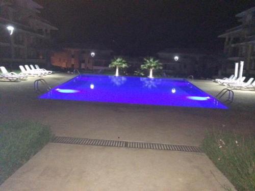 a large blue swimming pool at night at Prestigia PDN in Sidi Bouqnadel