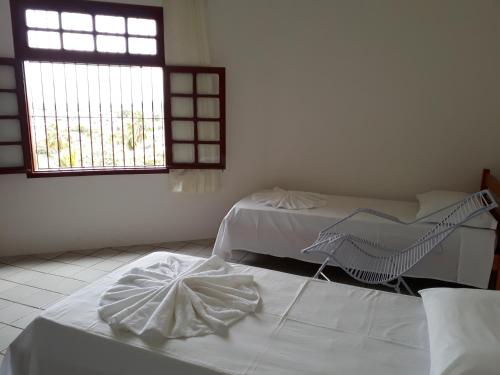 two beds in a room with a window at Pousada Convento da Conceição in Olinda