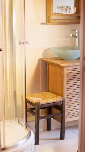 La salle de bains est pourvue d'un lavabo et d'un tabouret à côté d'une douche. dans l'établissement Domaine Gille, à Comblanchien