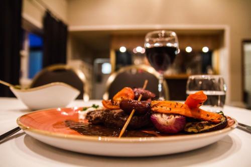 a plate of food on a table with a glass of wine at Hótel Fljótshlíd in Hlíðarendi