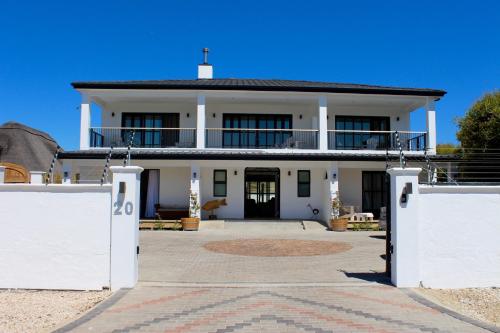 una casa blanca con una puerta delante de ella en Whale Rock Luxury Lodge en Hermanus