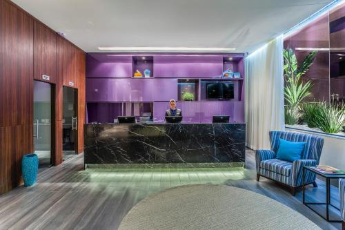 a woman sitting at a bar in a hotel lobby at Blue Tree Towers Bauru in Bauru