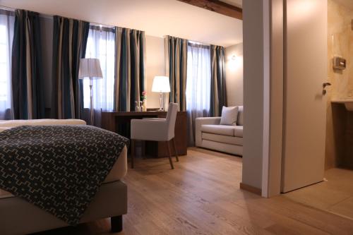 a hotel room with a bed and a desk and a chair at Markthotel Warendorf in Warendorf